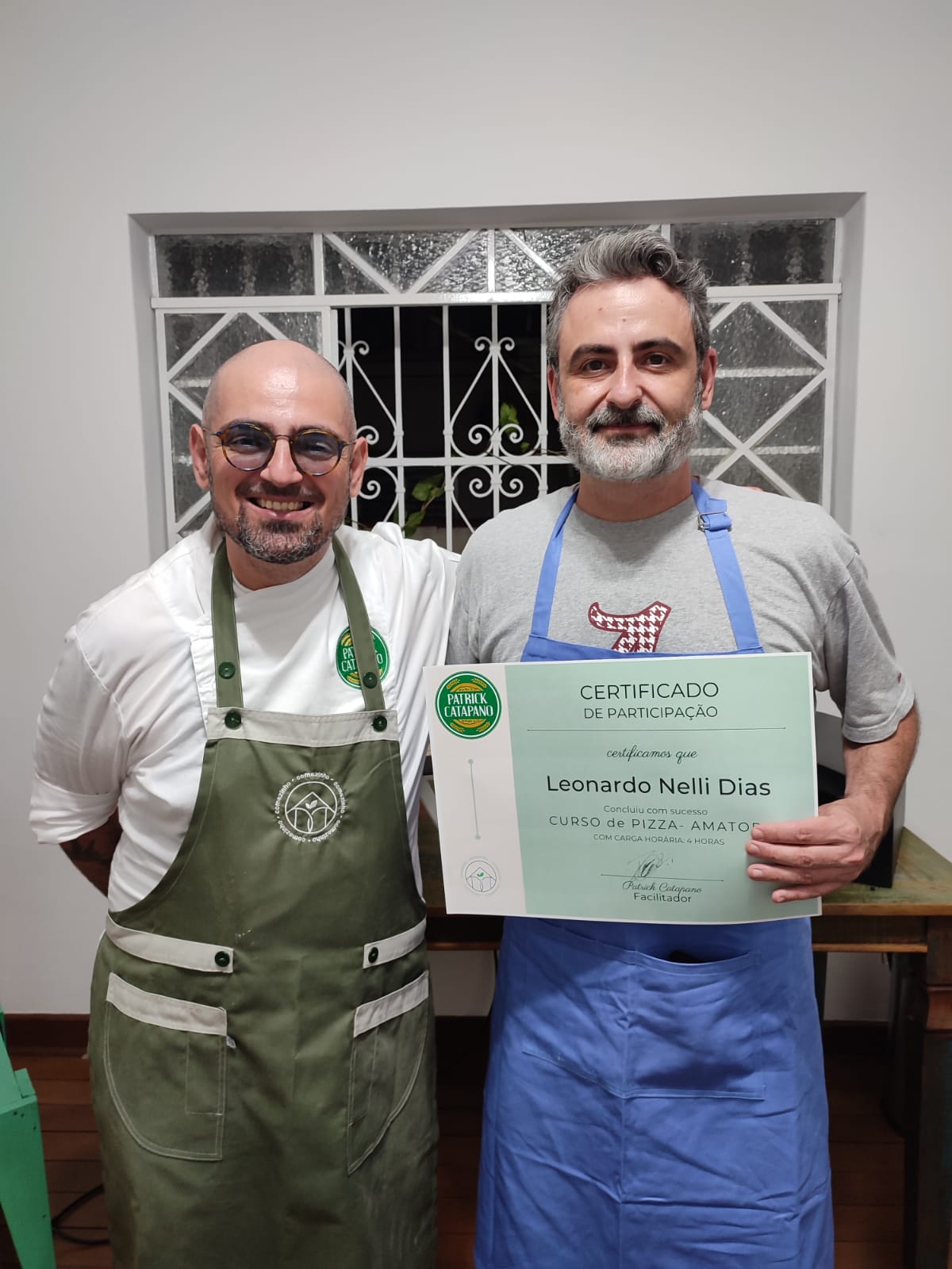 Leo Nelli ao lado do Maestro Patrick Catapano, segurando um certificado de participação em curso de pizza.