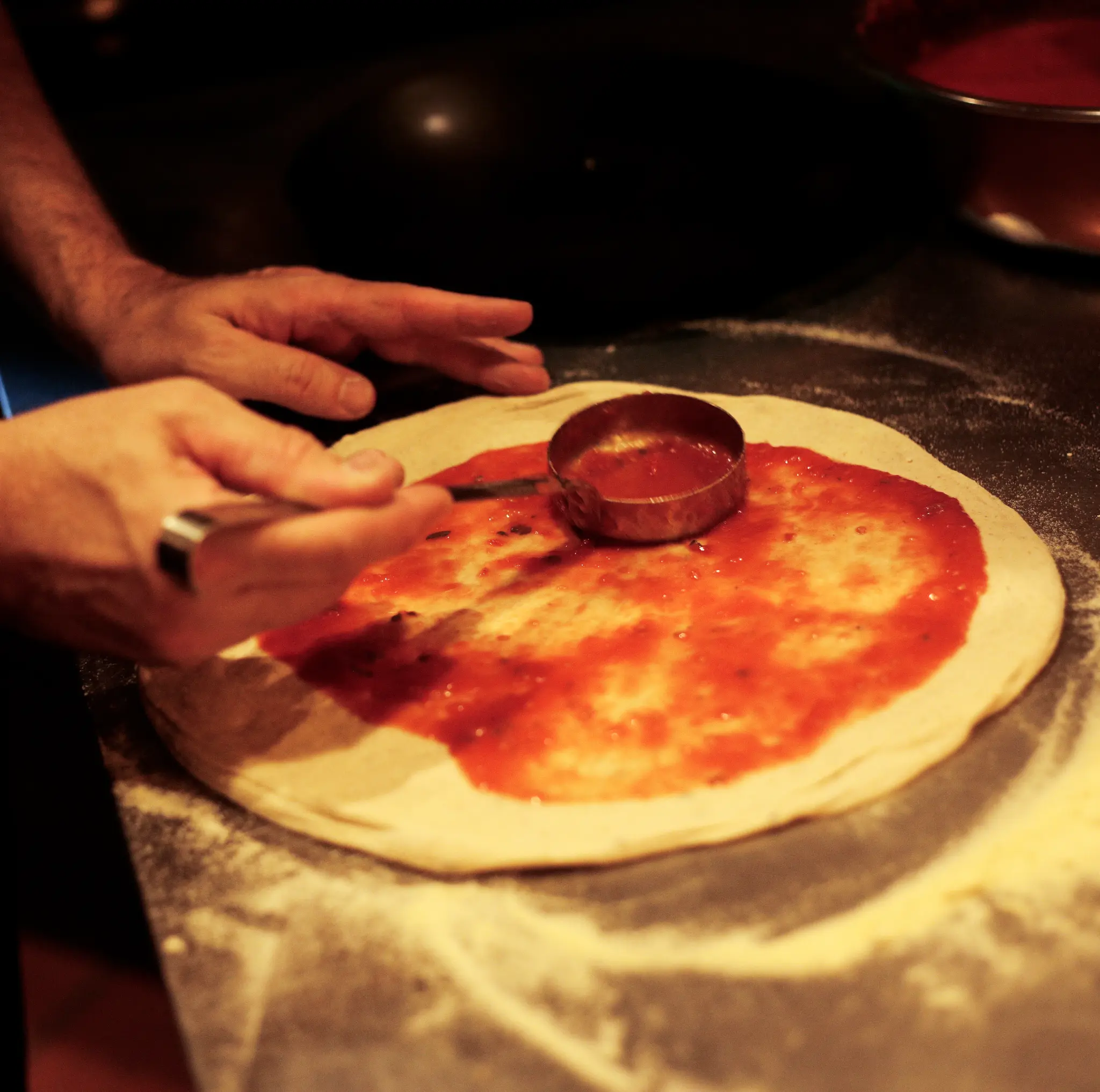 Massa de pizza sendo preparada antes de ir ao forno